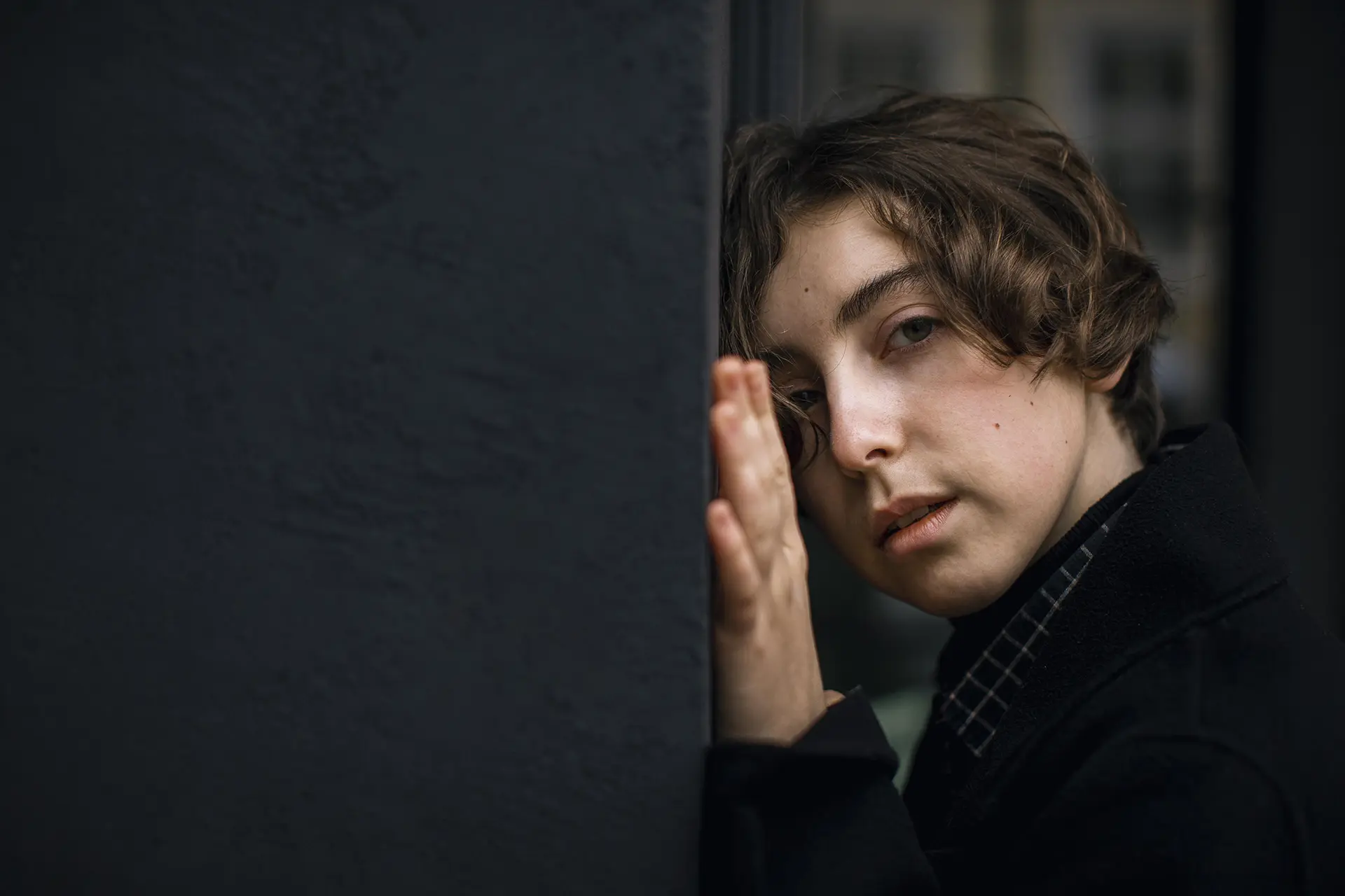 Ein Vater mit Depressionen hält sich den Kopf. Seine Augen sind geschlossen.